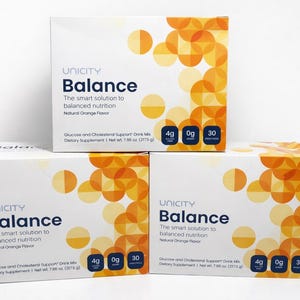 K&ouml;nnte beinhalten: Drei wei&szlig;e Kartons mit Unicity Balance Nahrungserg&auml;nzungsmittel. Jeder Karton zeigt den Produktnamen und die Beschreibung mit orangefarbenen und gelben Kreisdesigns. Die Kartons zeigen N&auml;hrwertangaben, darunter 4g Ballaststoffe, 0g Zucker und 30 Beutel.