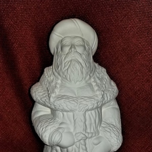 May include: White ceramic figurine of Santa Claus wearing a fur-trimmed coat and holding bells.