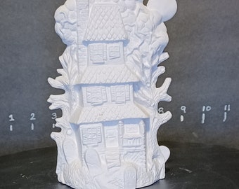 May include: White ceramic haunted house figurine with a spooky tree and a moon. The house has a chimney, windows, and a door. The figurine is perfect for Halloween decor.
