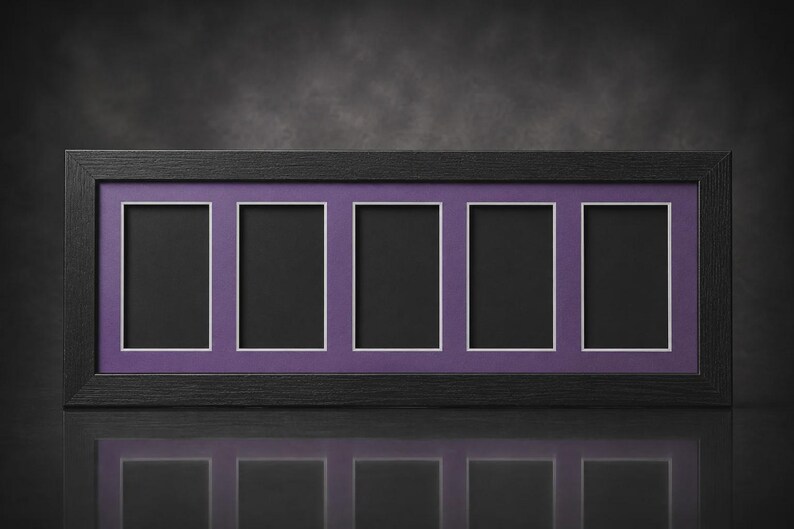 May include: A rectangular black picture frame with five openings. Each opening has a white border and a black interior, set against a purple background. The frame is displayed on a reflective surface.