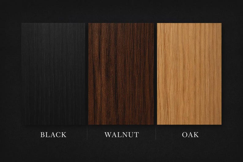 May include: Three wood samples: black, walnut, and oak. The black sample has a vertical grain pattern. The walnut sample is a dark brown color. The oak sample is a light tan color. The names of the wood types are written below each sample.