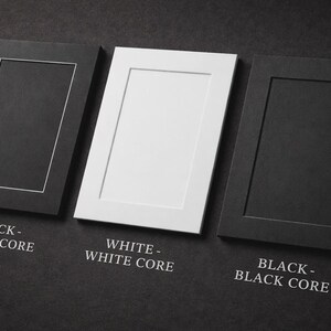 May include: Three rectangular picture frames in black and white, with the text "BLACK - WHITE CORE", "WHITE - WHITE CORE", and "BLACK - BLACK CORE". The frames are arranged on a dark gray surface.