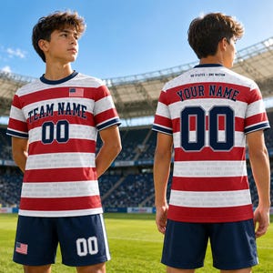 May include: A short-sleeved jersey and shorts set featuring a red and white horizontal striped pattern with navy blue accents. The jersey displays the text TEAM NAME and 00 on the front, and YOUR NAME and 00 on the back, with a small US flag patch.