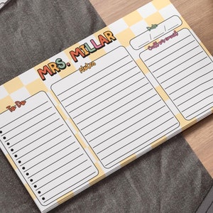 May include: A rectangular notepad featuring a yellow and white checkered pattern with the text MRS. MILLAR at the top. The layout includes sections labeled To-Do, Notes, Date, and Calls/Emails, each with lined spaces for writing and organizing tasks.