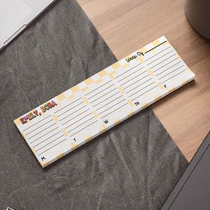 May include: A rectangular weekly planner with a yellow and white checkered pattern at the top. The planner has lines for each day of the week, with the days labeled M, T, W, TH, and F. The name "EMILY, BCBA" is printed in colorful letters.