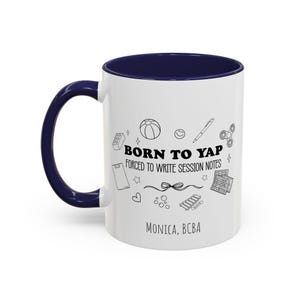 May include: White ceramic mug with a navy blue handle and interior. The mug features the text "BORN TO YAP FORCED TO WRITE SESSION NOTES" with various doodle illustrations. The name "MONICA, BCBA" is printed at the bottom.