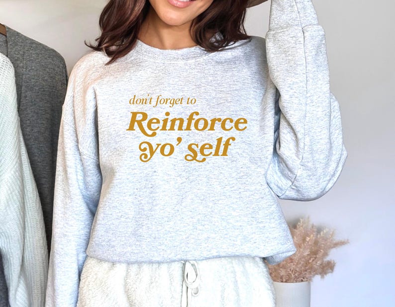 May include: A gray sweatshirt with the text "don't forget to Reinforce yo' self" in yellow.