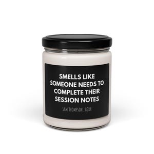May include: A white candle jar with a black label that reads "Smells like someone needs to complete their session notes. Sam Thompson, BCBA."