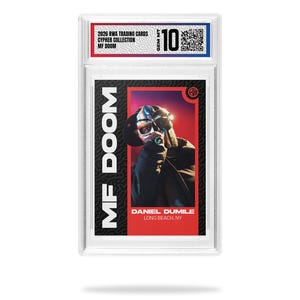 May include: A trading card featuring MF DOOM in a protective case. The card has a red and black design with the text "MF DOOM" vertically on the left. The card also includes the text "DANIEL DUMILE, LONG BEACH, NY" and "2026 RWA TRADING CARDS CYPHER COLLECTION MF DOOM".