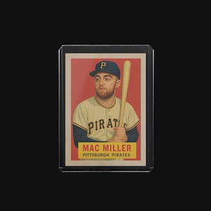 May include: A baseball card featuring a portrait of Mac Miller in a Pittsburgh Pirates uniform, holding a baseball bat. The card has a red background with the text "PIRATES" and "MAC MILLER PITTSBURGH PIRATES". The card is encased in a protective holder.