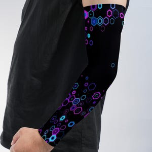 May include: An arm sleeve featuring a black background with a repeating pattern of neon purple and bright blue hexagonal shapes. The geometric design is concentrated at the wrist and upper arm, creating a vibrant contrast against the dark fabric.