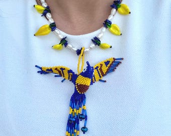 Zoetwaterparelketting met kleurrijke kristallen fruitkralen en een blauwe kolibrie van zaadkralen. Ideaal voor warm weer.