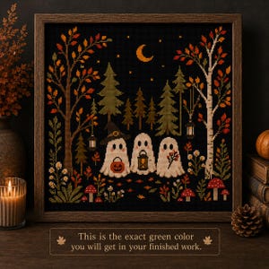 Peut inclure: Une broderie au point de croix encadrée représentant trois fantômes blancs dans une forêt sombre avec des arbres d'automne, des champignons et un croissant de lune. Le texte en bas indique : This is the exact green color you will get in your finished work.