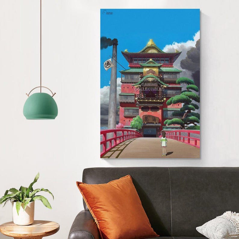 May include: A colorful anime-style print featuring a red building with a bridge and a person walking towards it. The building has green and gold accents, with the text "GAMING COLLECTIBLES" on the front. A tall smokestack is visible in the background.