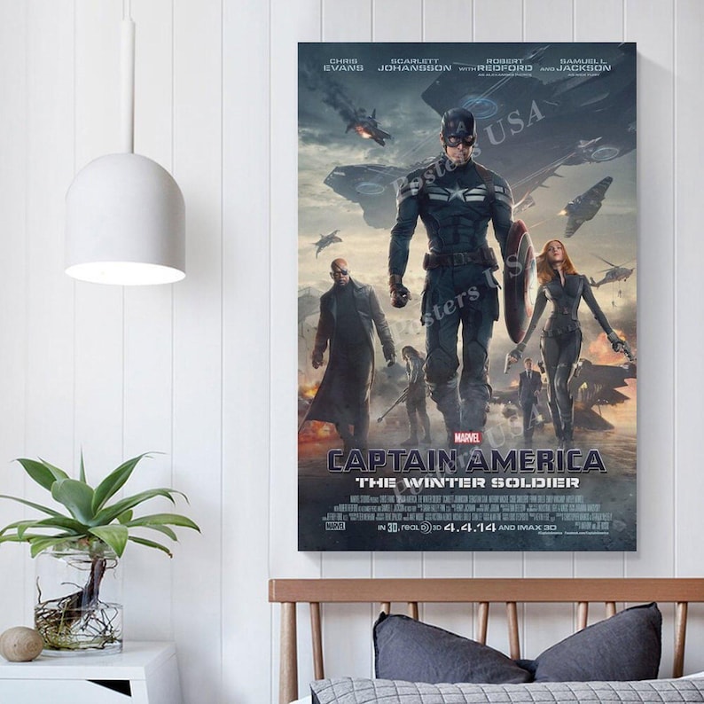 Puede incluir: Un p&oacute;ster enmarcado de la pel&iacute;cula Capit&aacute;n Am&eacute;rica: El Soldado de Invierno. El p&oacute;ster presenta al Capit&aacute;n Am&eacute;rica, Viuda Negra y otros personajes en una escena de batalla con una est&eacute;tica oscura y futurista. El t&iacute;tulo y el logotipo de Marvel son visibles.