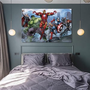 May include: A framed canvas print featuring a group of Marvel superheroes, including Iron Man, Hulk, Captain America, and Thor. The artwork depicts the characters in action against a city backdrop, with vibrant colors and dynamic poses. The print is displayed above a bed with gray bedding.
