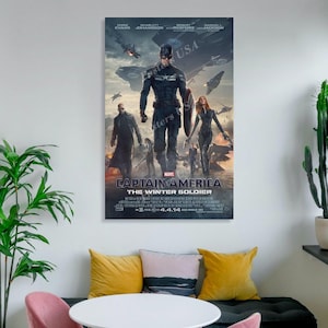 Puede incluir: Un p&oacute;ster enmarcado de la pel&iacute;cula "Capit&aacute;n Am&eacute;rica: El Soldado de Invierno" con el Capit&aacute;n Am&eacute;rica, Viuda Negra y otros personajes. El p&oacute;ster tiene una combinaci&oacute;n de colores oscuros con el t&iacute;tulo de la pel&iacute;cula y la fecha de lanzamiento visibles.