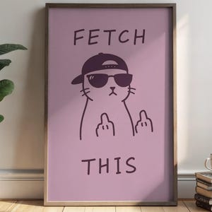 Könnte beinhalten: Gerahmtes Poster mit einem hellvioletten Hintergrund. Es zeigt eine Cartoon-Katze mit Sonnenbrille und Kappe, die den Mittelfinger zeigt. Die Worte "FETCH THIS" sind oberhalb und unterhalb der Katzenillustration gedruckt.