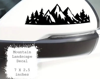 May include: Black and white mountain landscape decal for a car. The decal is 7 inches wide and 2.5 inches tall.  The decal features a mountain range with trees in the foreground.