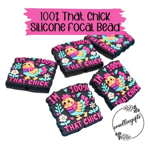 May include: Black silicone focal beads with a colorful cartoon chick design. Each bead has the text "I'M 100% THAT CHICK". The beads are decorated with flowers and leaves. The text "100% That Chick Silicone Focal Bead" is at the top.