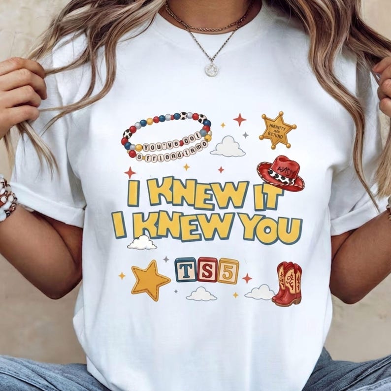 Retro western Toy Story 5 PNG graphic with bold yellow text, blue outline, cowgirl boots, friendship bracelet, sheriff badge, clouds, and sparkles.
Cute Toy Story 5 inspired shirt design with I Knew It I Knew You phrase, western boots, red cowboy hat, bracelet beads, toy blocks, and stars.