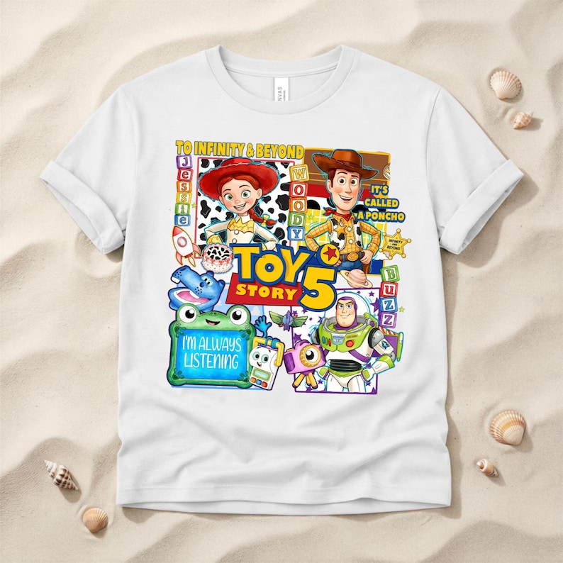 May include: A white short-sleeved t-shirt featuring a colorful graphic print of Toy Story characters including Jessie, Woody, and Buzz Lightyear. The design includes the text TO INFINITY & BEYOND, TOY STORY 5, IT'S CALLED A PONCHO, and I'M ALWAYS LISTENING.