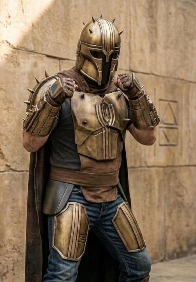 May include: A full-body suit of armor featuring a metallic bronze helmet with a T-shaped visor and spikes, matching shoulder pauldrons, gauntlets, and chest plate. The armor is worn over a dark shirt, blue jeans, and a long brown cape.