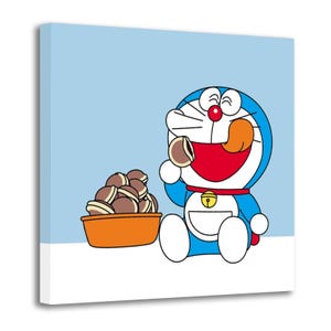 May include: A canvas print featuring the cartoon character Doraemon, a blue robotic cat, enjoying a snack. Doraemon is depicted with a red collar, a bell, and a white pocket. A bowl of dorayaki, a Japanese confection, sits nearby.