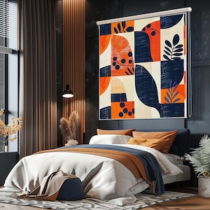 Può includere: Una camera da letto moderna con una tenda a rullo a fantasia sopra il letto. La tenda presenta un design geometrico nei colori arancione, blu navy e crema, con forme botaniche. Il letto ha lenzuola bianche e cuscini arancioni.