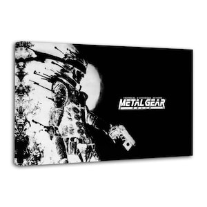 May include: A black and white rectangular wall art print featuring a stylised, ink-wash illustration of a soldier figure holding a handgun. The text METAL GEAR SOLID TACTICAL ESPIONAGE ACTION is printed in white on the right side of the composition.