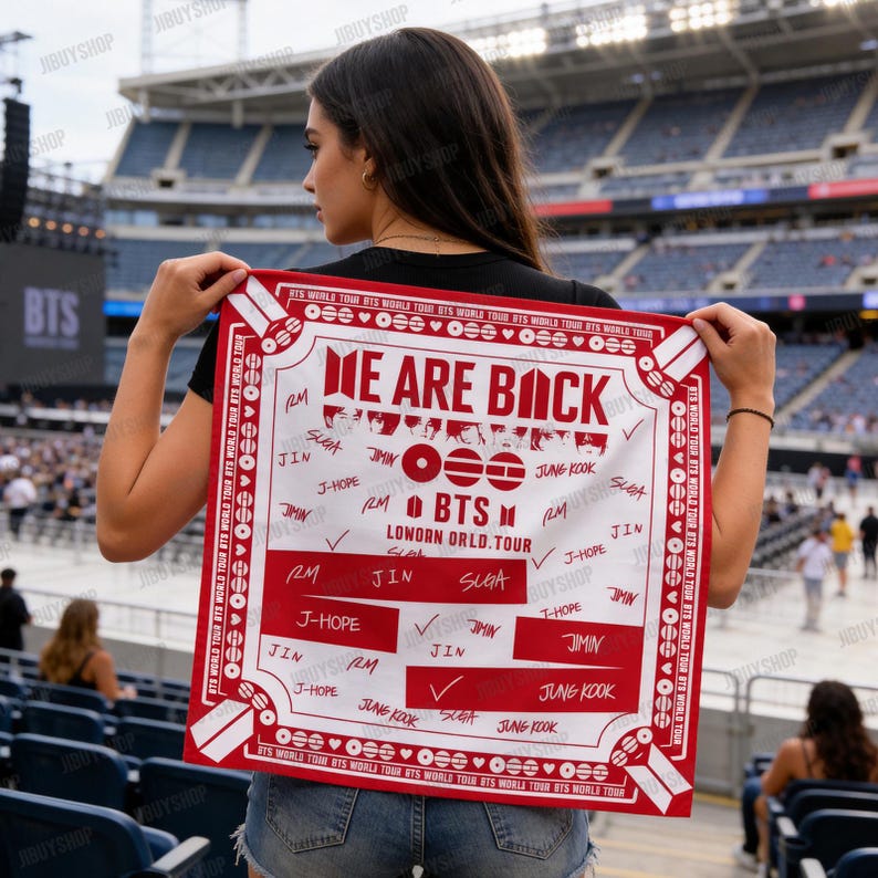 Peut inclure: Un bandana rouge et blanc avec le texte "WE ARE BACK" et "BTS LONDON ORLD. TOUR" dans un cadre de stade. Le bandana pr&eacute;sente les noms des membres du groupe et le logo BTS.
