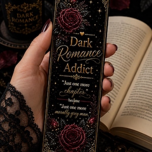 Könnte beinhalten: Ein rechteckiges schwarzes Lesezeichen mit goldenen Filigranrändern, dunkelroten Rosenillustrationen und dem Text: Dark Romance Addict, Just one more chapter, became, Just one more morally grey man. Das Design enthält ein kleines goldenes Herzsymbol.