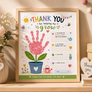 May include: A framed print with a light wood frame. The print features a handprint flower design with the words "THANK YOU for helping me grow." Includes fill-in-the-blank prompts and a heart-shaped thank you note.