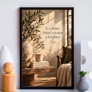 May include: A framed wall art print featuring a scene with a textured vase, a mug, and a stack of three books titled A Quieter You, A Happier Home, and A Brighter Tomorrow. The text A calmer mind creates a brighter life is printed in the center.