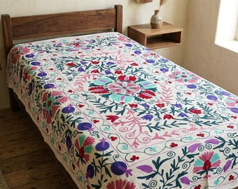 Colcha Suzani floral bordada a mano, estilo bohemio tradicional, de algodón en color rosa empolvado.