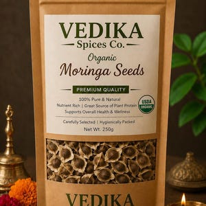 May include: A brown stand-up pouch containing Vedika Spices Co. organic moringa seeds. The label features the text 'VEDIKA Spices Co. Organic Moringa Seeds', 'PREMIUM QUALITY', '100% Pure & Natural', and 'Net Wt. 250g' with a clear window showing the seeds.