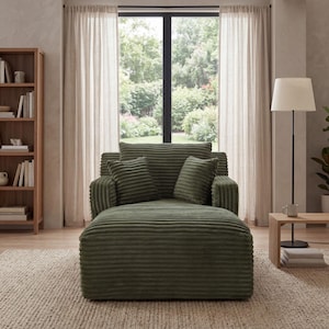 May include: An olive green corduroy chaise lounge with two matching throw pillows. The lounge is in a living room setting with a wooden bookshelf, a floor lamp, and a window with sheer curtains. The room has a neutral color palette.