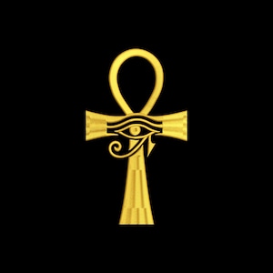 May include: A gold-colored Ankh pendant with the Eye of Horus symbol, set against a black background. The Ankh, an ancient Egyptian symbol of life, features a loop, a horizontal bar, and a vertical bar.