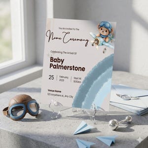 Puede incluir: Una tarjeta de invitación para una ceremonia de nombre con una ilustración en acuarela de un osito de peluche piloto en un avión azul. El texto dice: You Are Invited To The Name Ceremony, Celebrating The Arrival Of Baby Palmerstone, 25 February, 2023, 9.00Am.