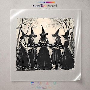 May include: A square DTF transfer sheet featuring a black and white illustration of five figures in pointed hats and long dresses standing in a circle in a forest. The text Girls Will Be Girls is printed in a white rectangular bar across the center.