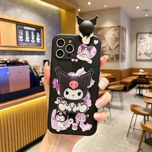 May include: Black phone case featuring a cartoon character with a black head and pink accents. The case has a 3D figure at the top and additional character illustrations. The design includes hearts, flowers, and the word "OPEN".