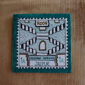 May include: A white ceramic mug with a black handle and the text "But First, Coffee" in a black, bold font. The mug is on a white surface.