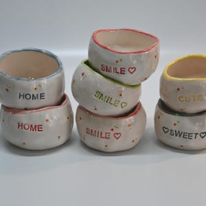 Könnte beinhalten: Rustikales Holzschild mit dem Text "Welcome to our home" in weißer Schrift. Das Schild hat eine Used-Optik und ein schlichtes, einladendes Design, perfekt für die Dekoration.