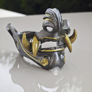 May include: A white ceramic mug with a black handle and the text "But First, Coffee" in a black, handwritten-style font. The mug is on a white surface.