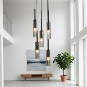 May include: A multi-light pendant fixture featuring five cylindrical, smoke-tinted glass shades suspended at varying heights. Each shade houses a single glowing bulb, attached to thin black metal rods that extend upward to a central ceiling mount.