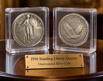 May include: Two silver 1916 Standing Liberty Quarter coins in clear protective cases. One coin shows Liberty with a shield, the other an eagle. A gold plaque below reads "1916 Standing Liberty Quarter Uncirculated Silver Coin."