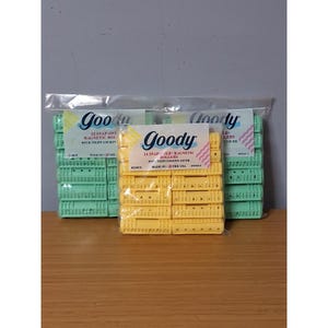 May include: Three clear plastic packages of Goody snap-over magnetic rollers. The center package contains 14 yellow medium rollers, while the two outer packages contain 12 large light green rollers each, all featuring tight-locking covers.