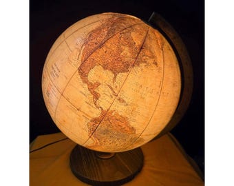 May include: A vintage-style illuminated globe with a detailed map of the world. The globe is lit from within, showcasing the continents in warm tones. It sits on a dark wooden base, with a dark background.