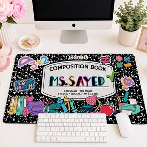 Könnte beinhalten: Eine rechteckige Schreibtischunterlage mit schwarz-weißem Kompositionsheft-Muster, bunten Schulmotiven und dem Text "COMPOSITION BOOK", "MS. SAYED", "100 Sheets 200 Pages", "9 3/4 in x 7 1/2 in (24.7 cm x 19 cm)" sowie "I LOVE MATH".