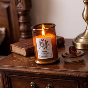 Handcrafted scented candle in an amber glass jar with a lid